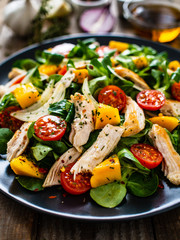 Caesar salad - fried chicken breast and vegetables on wooden table
