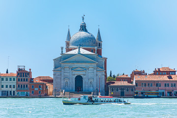 Church of Ile Redentore on the island of Judecca, washed by emerald green water oh a canal (Canale della Giudecca). Venice, Italy, Europe.