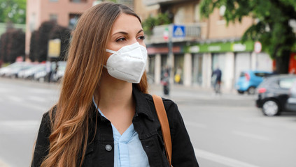 COVID-19 Pandemic Coronavirus Woman in city street wearing KN95 FFP2 mask protective for spreading of disease virus SARS-CoV-2. Girl with protective mask on face against Coronavirus Disease 2019.