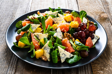 Fresh salad - blue cheese, fruit and vegetables on wooden table

