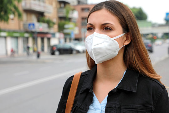 COVID-19 Pandemic Coronavirus Woman in city street wearing KN95 FFP2 mask protective for spreading of disease virus SARS-CoV-2. Girl with protective mask on face against Coronavirus Disease 2019.