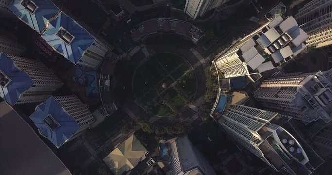 Orbiting ascending aerial flight over roundabout intersection in urban area. Drone, 4K.