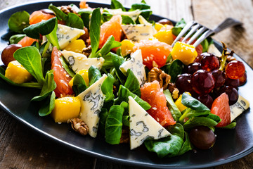 Fresh salad - blue cheese, fruit and vegetables on wooden table
