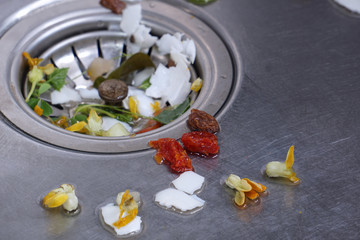 Food waste from the washing up in the sink and trash traps grid of drainage holes.