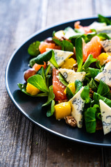 Fresh salad - blue cheese, fruit and vegetables on wooden table
