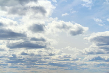 Clouds in the blue sky at sunset or dawn backlit by the sun. Place for text and design.