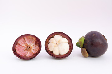 Half of the mangosteen fruit and one mangosteen placed side by side on a white ground.