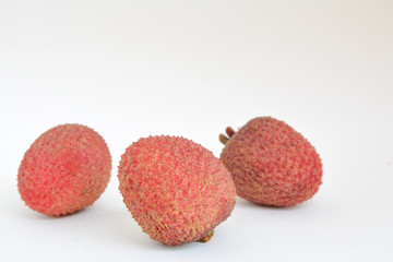 Three lychee fruits on a white background