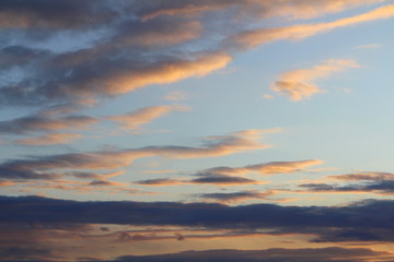 Clouds in the sky are illuminated from below by the red light of the sun. Sunset or sunrise scene at dusk.
