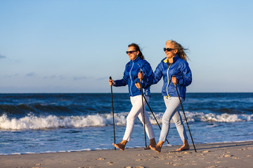 Nordic walking - two women working out on beach