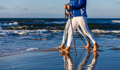 Nordic walking - two women working out on beach