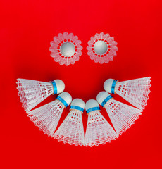 smiley made of plastic  Badminton shuttlecock on the red  background. Design of a shuttlecock. Badminton accessories. Sports equipment. place for text