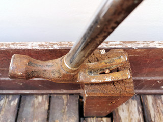 Old rusty hammer pulling a rusty screw out of the wood. Selective focus on the top of the screw. ...