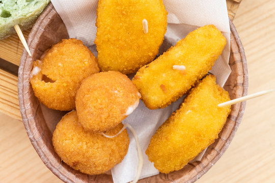 Morning aperitif at the bar. Fried mozzarella and fried cheeses served on a plate during a June morning.