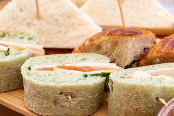 Morning aperitif at the bar. Sandwiches served on a wooden plate on a June morning.