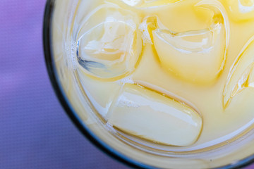 Morning breakfast in a bar in Bari, a city in the south of Italy. A pear and mango fruit juice with ice cubes served on a table.