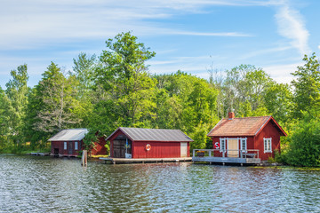 Beautiful red cottage and boathouse at a lakeshore