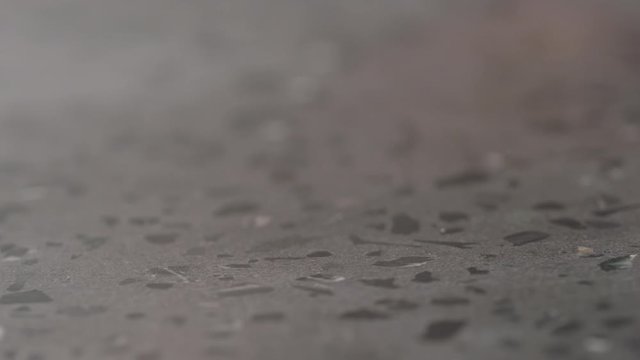 Slow motion spraying sanitizer on concrete countertop surface and wipe it macro shot