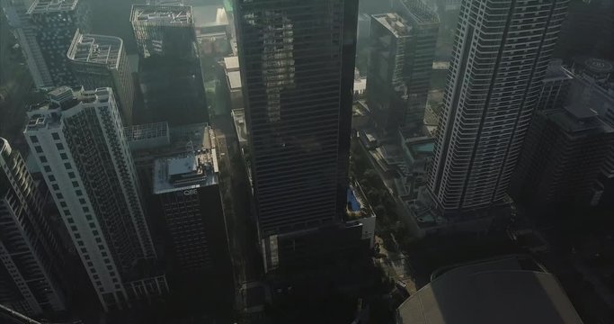 Tilt up aerial flight of urban area revealing high rise buildings. Drone, 4K.