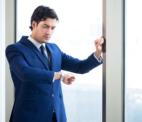 Young handsome businessman standing at the window