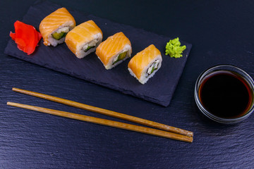 Sushi rolls Philadelphia on a black slate