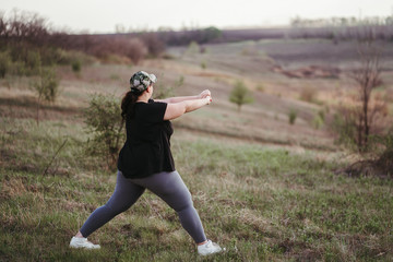 Overweight woman doing yoga outdoors. Healthy lifestyle, sport, weight losing, activity concept