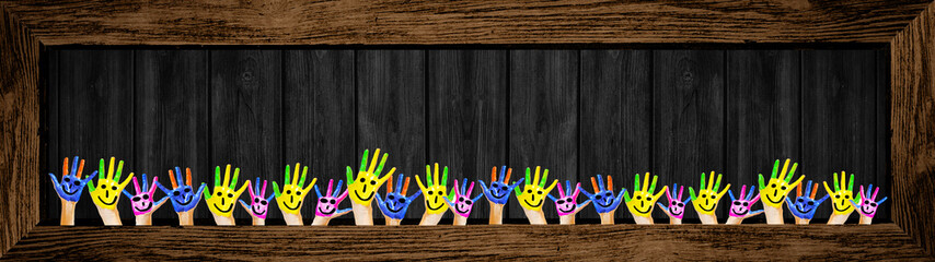 School background banner panorama - Many brightly painted children's hands in front of a old aged...