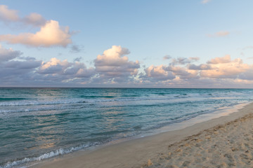 Obraz premium Sunset at the beach. Horizon line between ocean and cloudy sky.