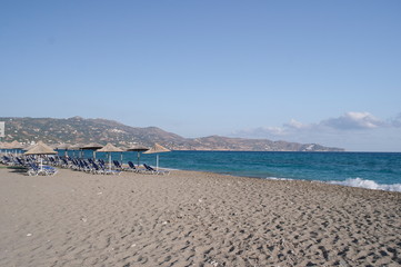 straw beach umbrella on a sandy beach near the Mediterranean sea