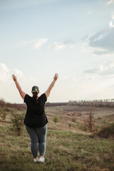 Life goals and achievement. Happy woman standing in nature. Female runner raising arms expressing positivity and success.