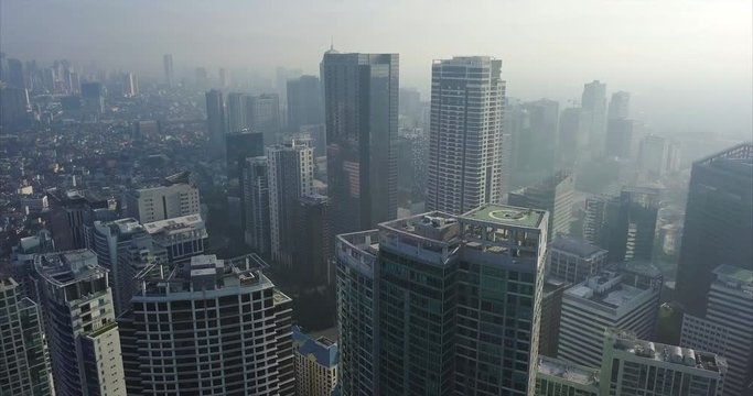 Ascending aerial flight over busy metropolitan city's skyline. Drone, 4K.