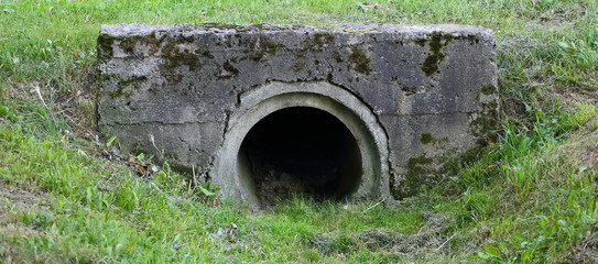 Fototapeta na wymiar Drainage pipe connecting the ditch under the bridge in the Park