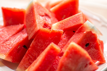 The background of the red flesh watermelon, placed in a ready-to-eat white plate, is a fruit that has a sweet taste and is an alternative health menu.