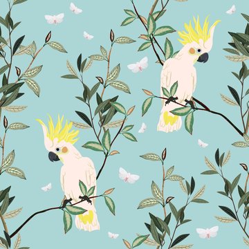 Seamless vector pattern with white parrots sitting on green branches on a gentle light blue background. Square template with exotic birds and leaves for fabric and wallpaper