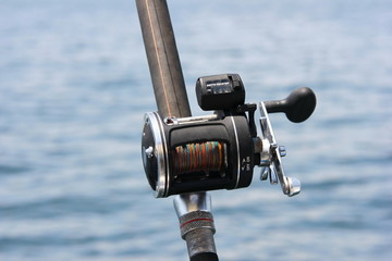 trolling coil against the sea. close-up. fishing supplies.