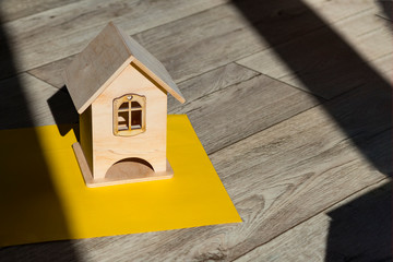 Obraz na płótnie Canvas Mock up little wooden house. Bright shadows casts on the background. Close-up. There is a tint