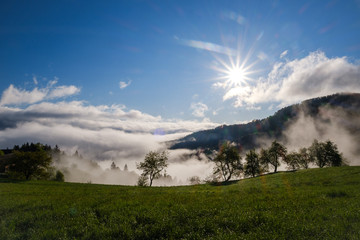 View through clouds and morning fog from Rantovse towards Skofja Loka hills