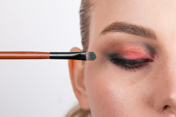 Part of the girl's face with bright eye makeup on a white background, a blank for design.