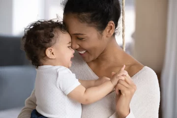 Fototapeten Close up of happy young african American mother hug cuddle little infant or toddler, loving smiling biracial mom embrace small baby child, enjoy tender family moment, motherhood, childcare concept © fizkes