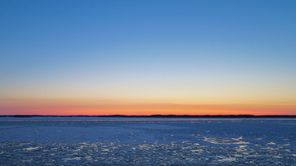 Fototapeta na wymiar Ice drifts on the Baltic sea in spring evening, after sunset.