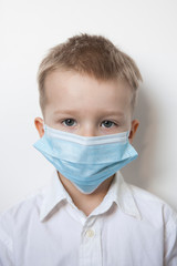Cute boy in a medical mask. Quarantined children due to an epidemic.