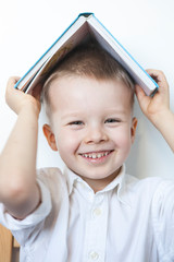 Adorable Toddler Boy With Book On Head.