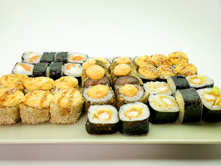 sushi rolls with salmon and shrimp sprinkled with sesame seeds, close-up.