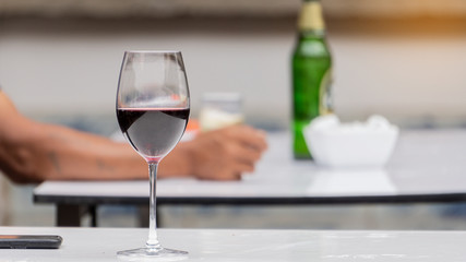 A red wine glass on the table with a blurred background