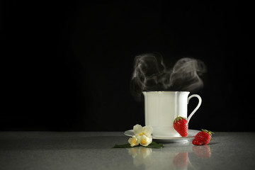 White porcelain teacup with thick steam in the form of a heart. on a dark background with a copy of the space. A fabulous concept.