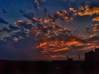 Beautiful dramatic sky in the morning with heavy clouds and orange sunlight.