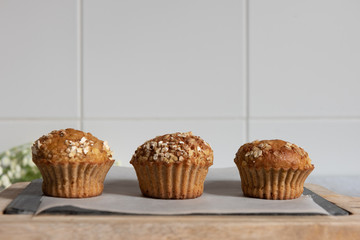Fresh homemade delicious carrot muffins decorated with oat flakes and brown sugar on rustic table
