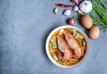 Close-up of two shrimps with vegetable sour curry Thai soup with Acacia Pennata omelet and shrimps in a white bowl on the table. The idea of healthy herbal ingredient food and cooking stay home.