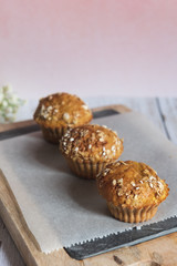 Fresh homemade delicious carrot muffins decorated with oat flakes and brown sugar on rustic table