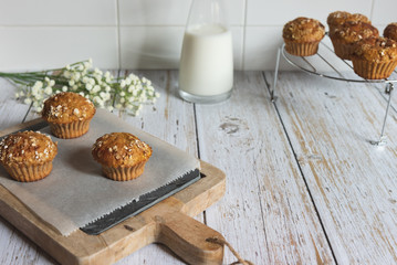 Fresh homemade delicious carrot muffins decorated with oat flakes and brown sugar on rustic table